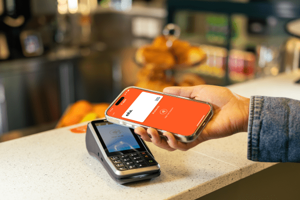 Mobil med Vipps åpen, som holdes mot en betalingsterminal i butikk. 